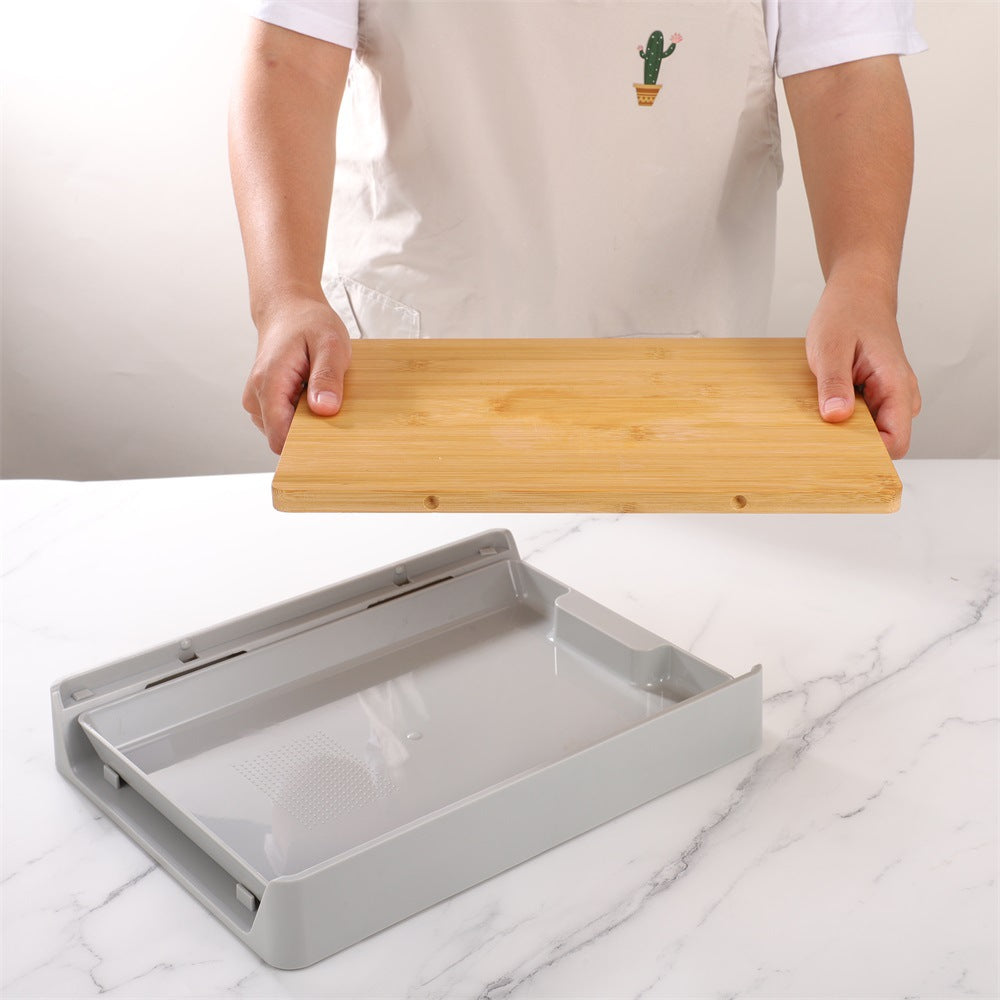 Person holding a wooden cutting board above a gray tray on a marble surface.
