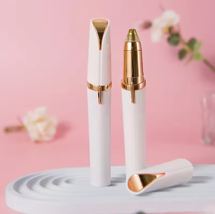 White and gold Electric Eyebrow Trimmer on a pink background