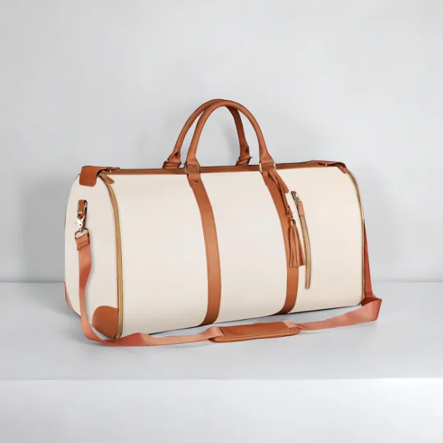 Beige duffel bag with brown leather straps on a light gray background