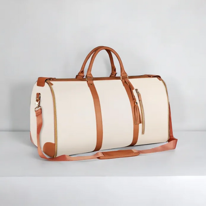 Beige duffel bag with brown leather straps on a light gray background