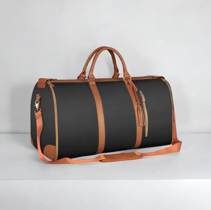 Black duffel bag with brown leather accents on a light gray background